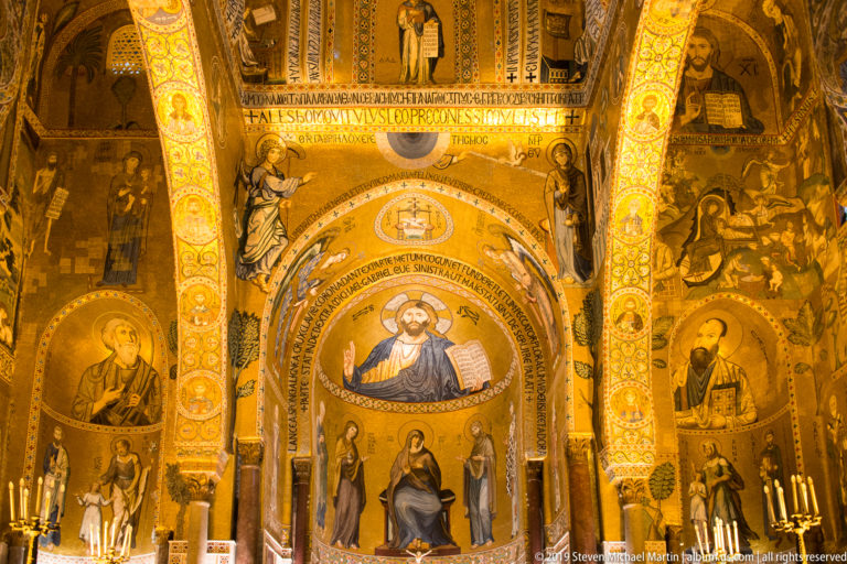 Christ Pantocrator appears above the enthroned Virgin and Child and standing saints in a richly inscribed gold mosaic apse.
