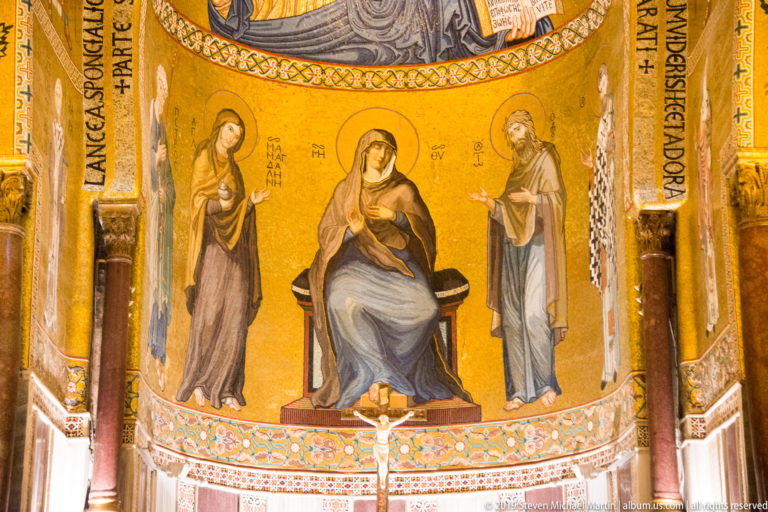 Enthroned Virgin and Child on a gold mosaic ground, flanked by two standing saints above patterned marble decoration.