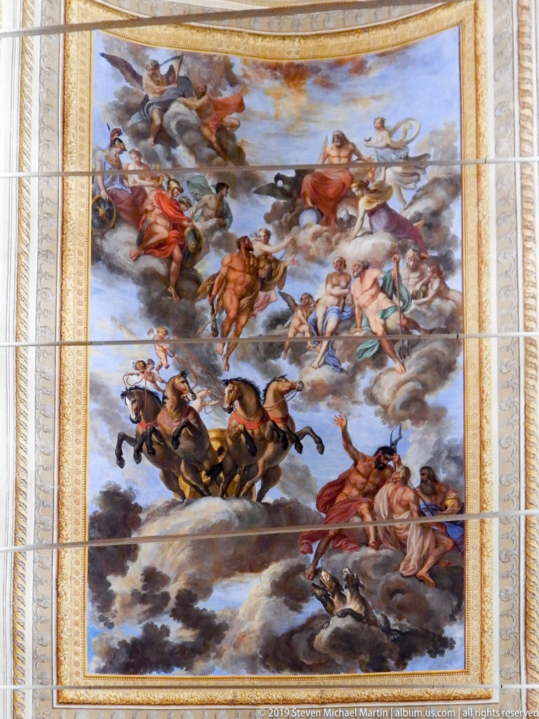Mythological ceiling painting with chariots, horses, and airborne figures.