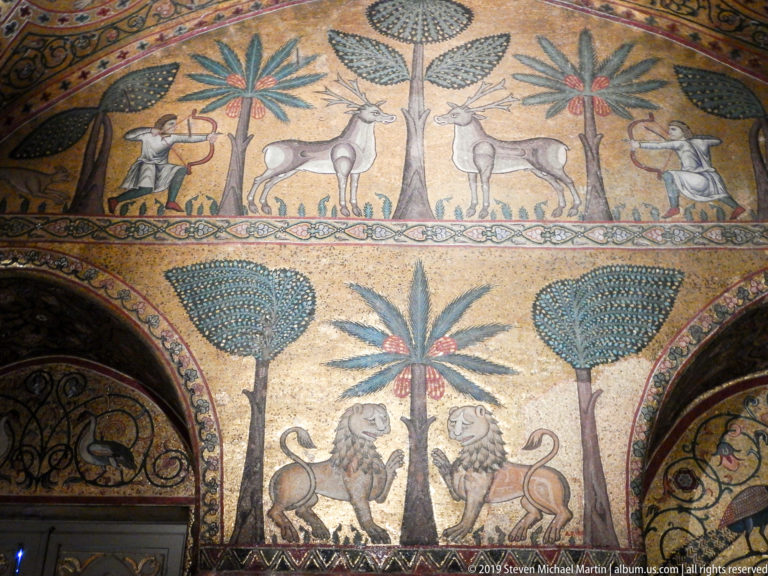 Two-register animal mosaic with quadrupeds, lions, palms, and stylized trees.