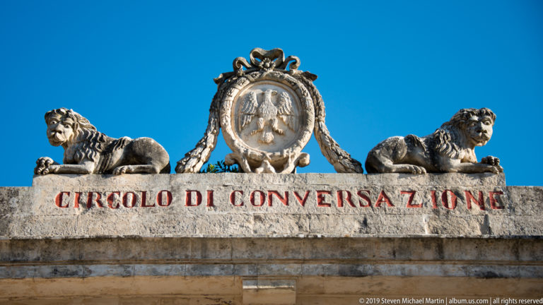 Two stone lions flank an oval crest above the red inscription “Circolo di Conversazione.”