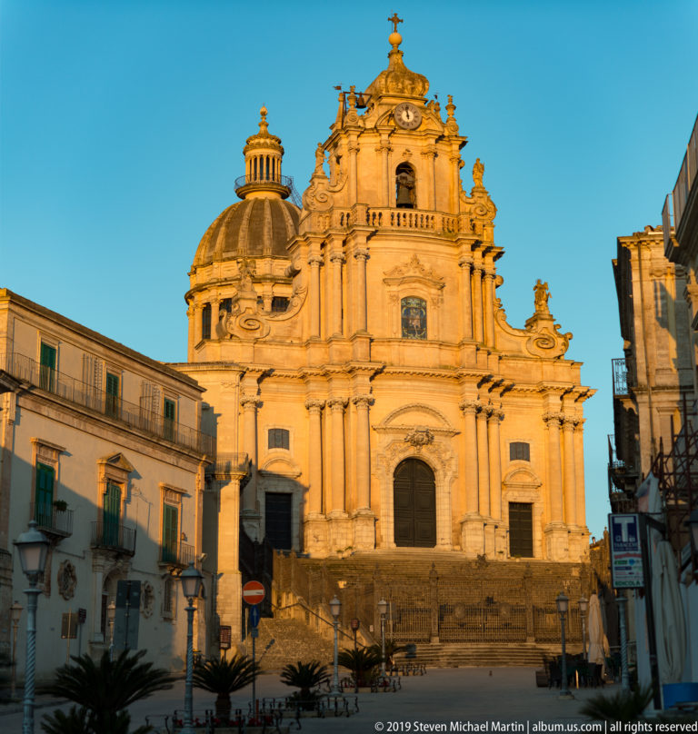 Ornate Baroque façade and dome of the Cathedral of San Giorgio glowing in warm sunlight in Ragusa Ibla.