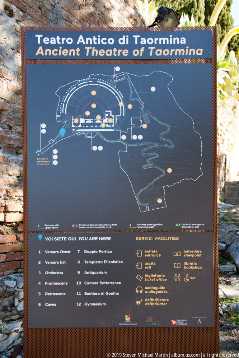 Dark visitor information panel with a plan of the Ancient Theatre of Taormina and labeled facilities.