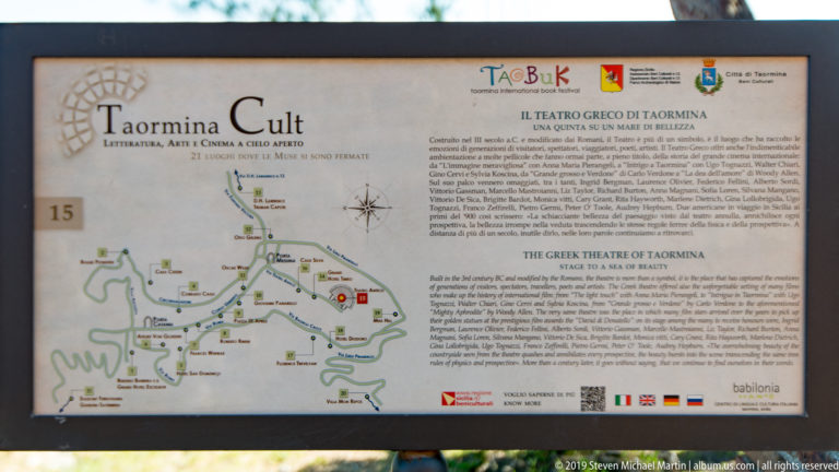 Outdoor interpretive sign with a site map and bilingual text about the Ancient Theatre of Taormina.