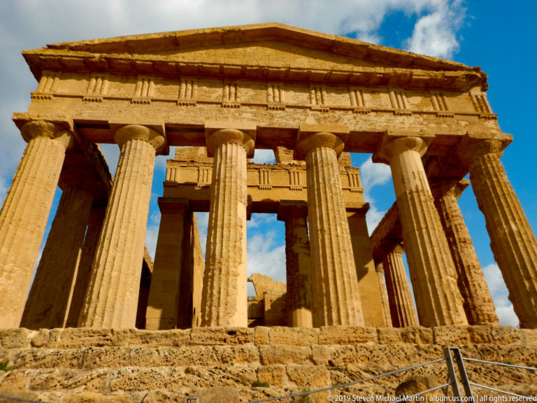 Frontal low-angle view of the Temple of Concordia with six columns, triangular pediment, and visible inner structure.