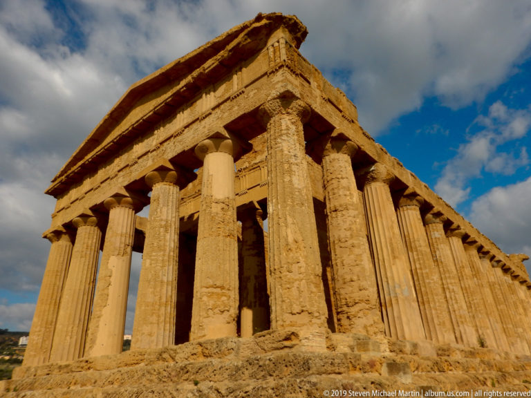 Low corner view of the Temple of Concordia with tall Doric columns, continuous entablature, and pediment.