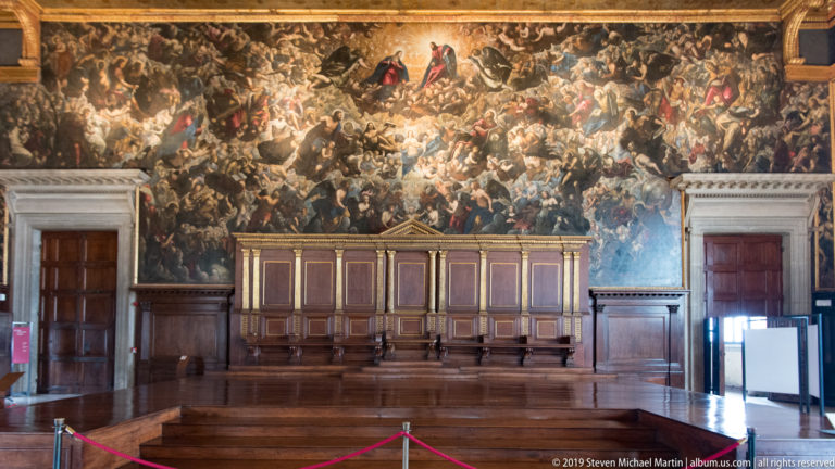 Frontal view of the Great Council Chamber with Tintoretto’s Paradise above the long raised wooden dais.