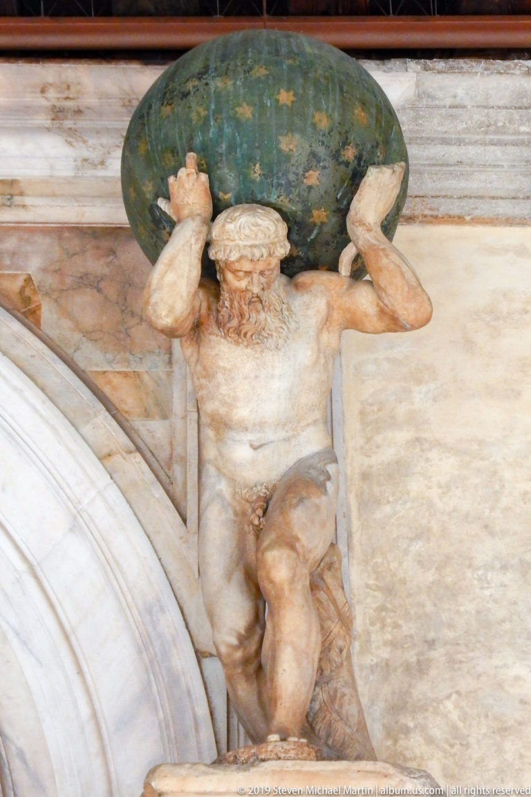 Bearded nude male figure crouching beneath a blue-green globe painted with gold stars above an arch.