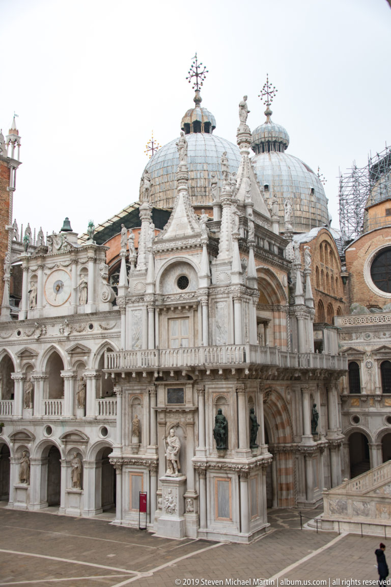 Full view of the ornate Arco Foscari in the courtyard, with St Mark’s Basilica domes behind.