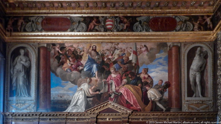 Large ceremonial painting with an elevated blue-robed woman, kneeling figure, attendants, columns, and statues in side niches.
