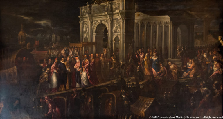 Dark historical painting of a crowded civic procession or reception before brightly illuminated monumental classical architecture.