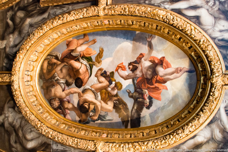 Oval ceiling painting of allegorical figures surrounded by a broad, richly molded gilded frame.
