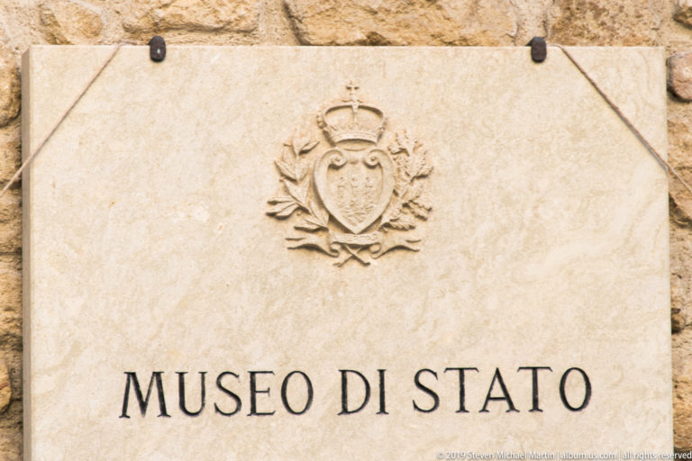 Stone plaque reading MUSEO DI STATO with a carved crowned San Marino coat of arms above the inscription.