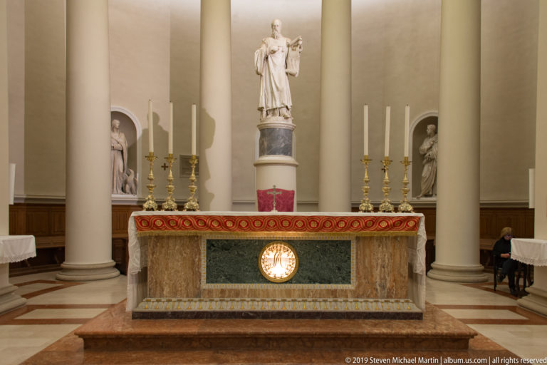 Basilica of Saint Marinus high altar with gold candlesticks and Adamo Tadolini’s marble Saint Marinus holding the LIBERTAS tablet above.