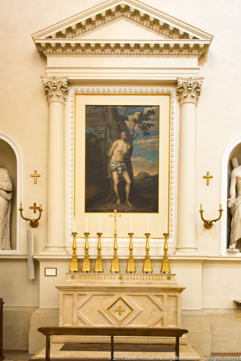 Elisabetta Sirani’s Noli Me Tangere, showing the risen Christ in a landscape, displayed above a side altar with gold candlesticks.