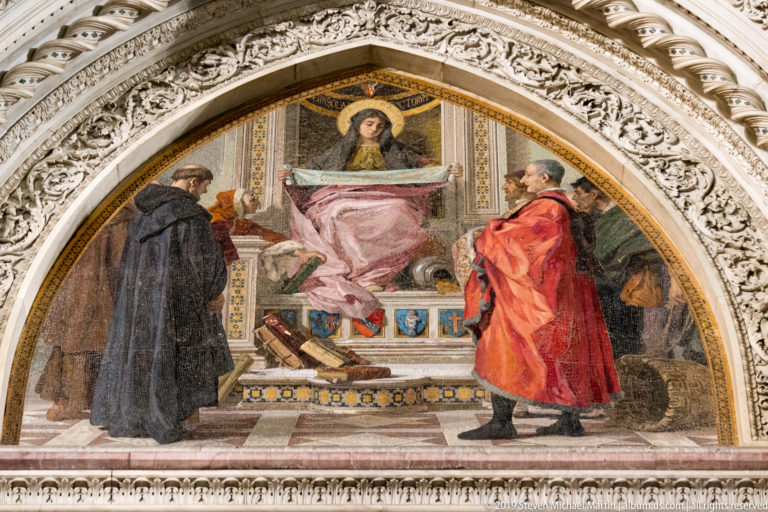 Semicircular mosaic of a seated haloed figure between two standing men, framed by richly carved marble.
