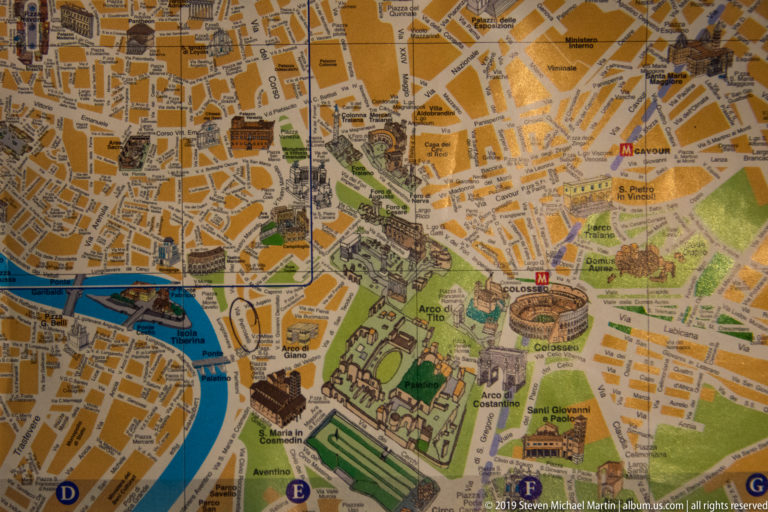 Detailed printed map of central Rome showing the Tiber, Colosseum, Roman Forum, Circus Maximus, streets, and monuments.