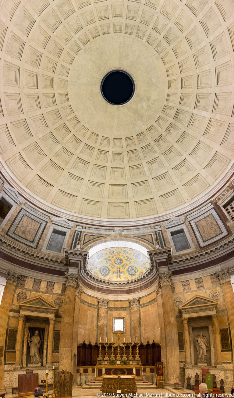 Wide Pantheon interior showing altar and apse below the vast coffered dome and dark circular oculus.