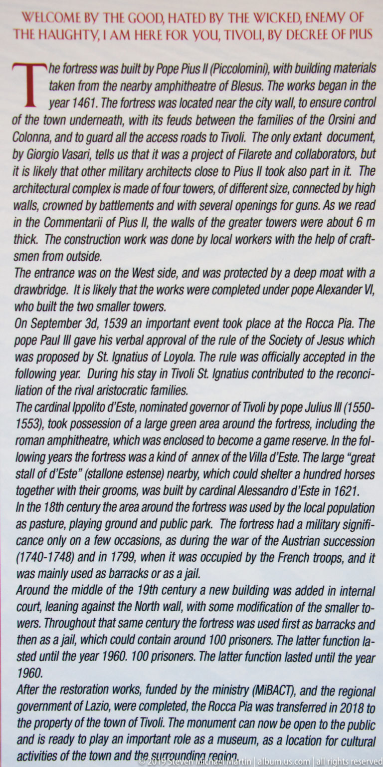 Large English interpretive sign with dense historical text about Rocca Pia in Tivoli.