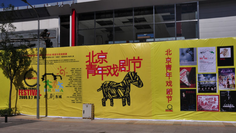 Large yellow banner for the 2009 Beijing Youth Theater Festival with red Chinese and English text and a black zebra graphic.