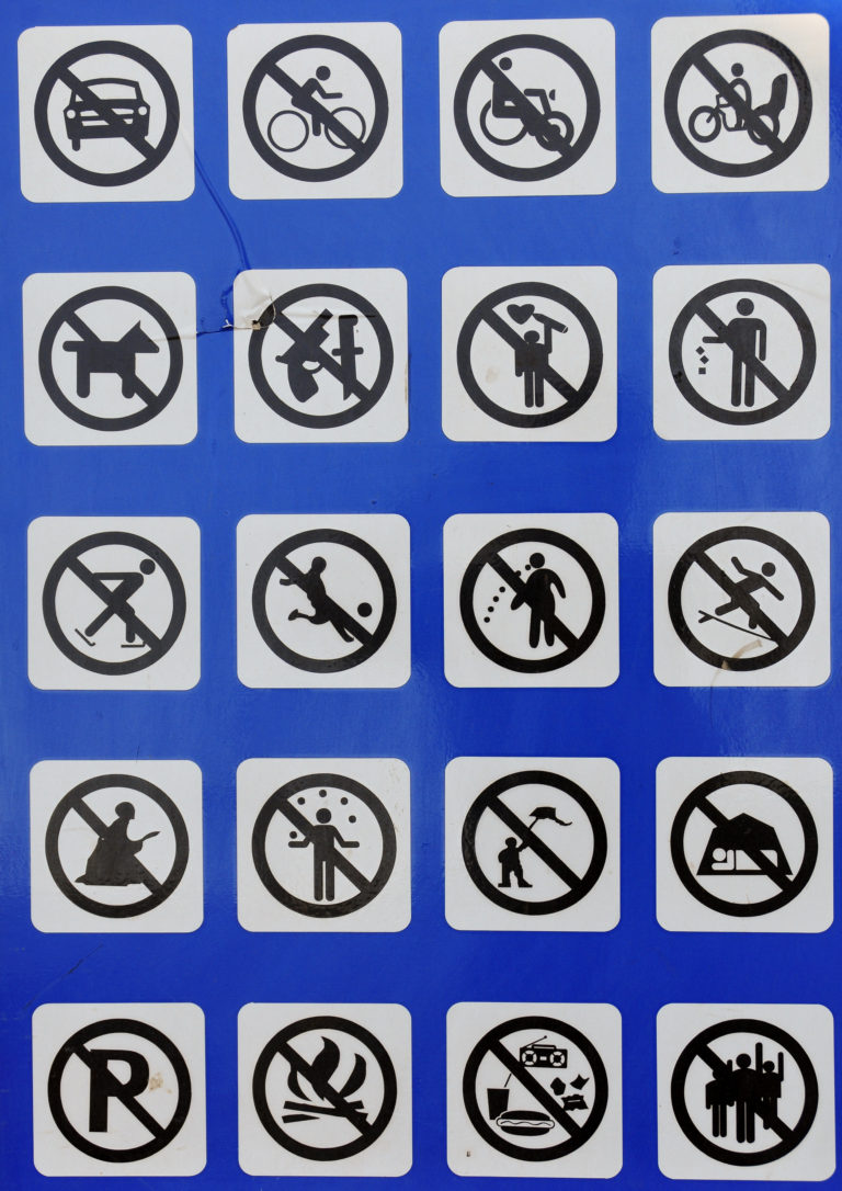 Blue public sign in Beijing displaying multiple prohibition pictograms, including no skating, no ball games, and no climbing.