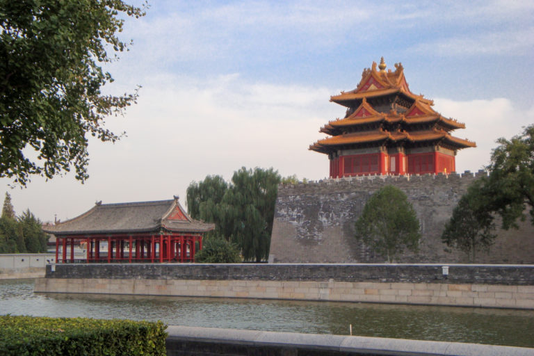 Corner tower of the Forbidden City beside the calm palace moat in Beijing.