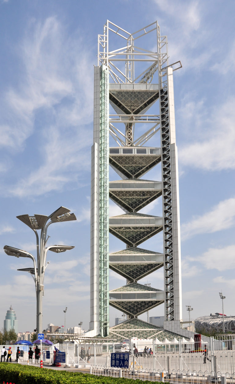 Steel tower with stacked triangular platforms and exposed lattice structure at Beijing’s Olympic Green.