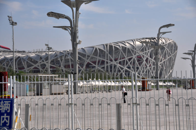 Beijing National Stadium’s Bird’s Nest steel lattice behind security fencing at the entrance area.