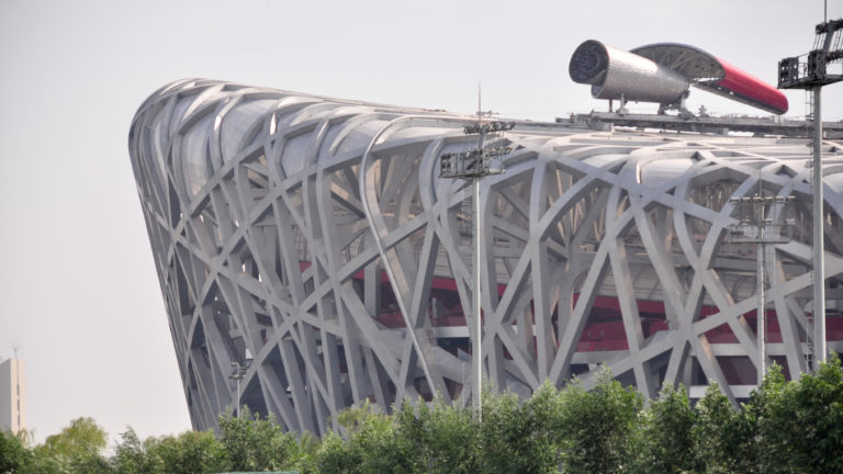 Close view of the irregular interwoven steel lattice of Beijing National Stadium, known as the Bird’s Nest, showing its exposed structural frame and oval stadium form.