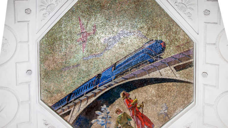 Polygonal ceiling mosaic with a streamlined blue vehicle, red figure, and airborne form framed by white plaster panels.