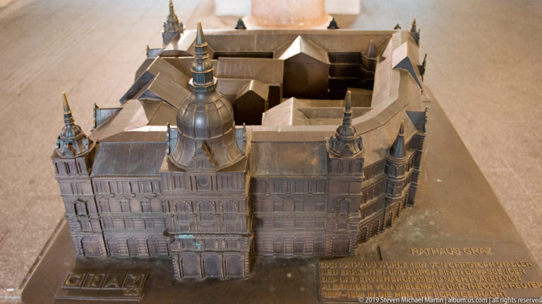 Bronze miniature of Graz City Hall seen from above, with the raised inscription RATHAUS GRAZ beside it.