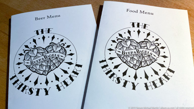 Two white menu covers reading “Beer & Bagels” and “The Thirsty Heart,” one labeled Food Menu.