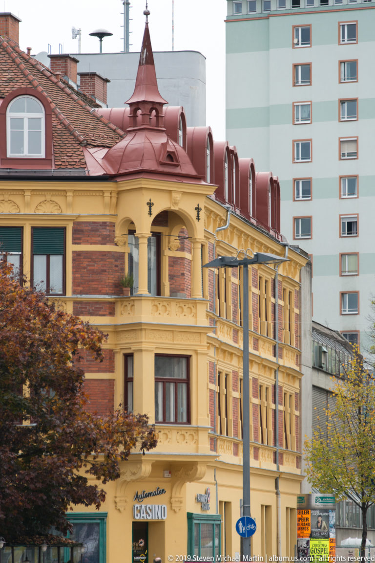 Ornate yellow corner building with red roof details, tall windows, carved decoration, and casino signage at street level.