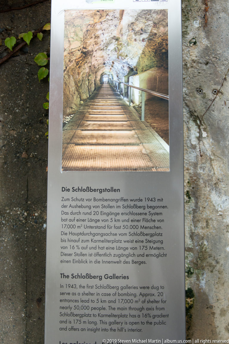 Interpretive panel about the Schlossberg Galleries with tunnel photograph and German-English text.