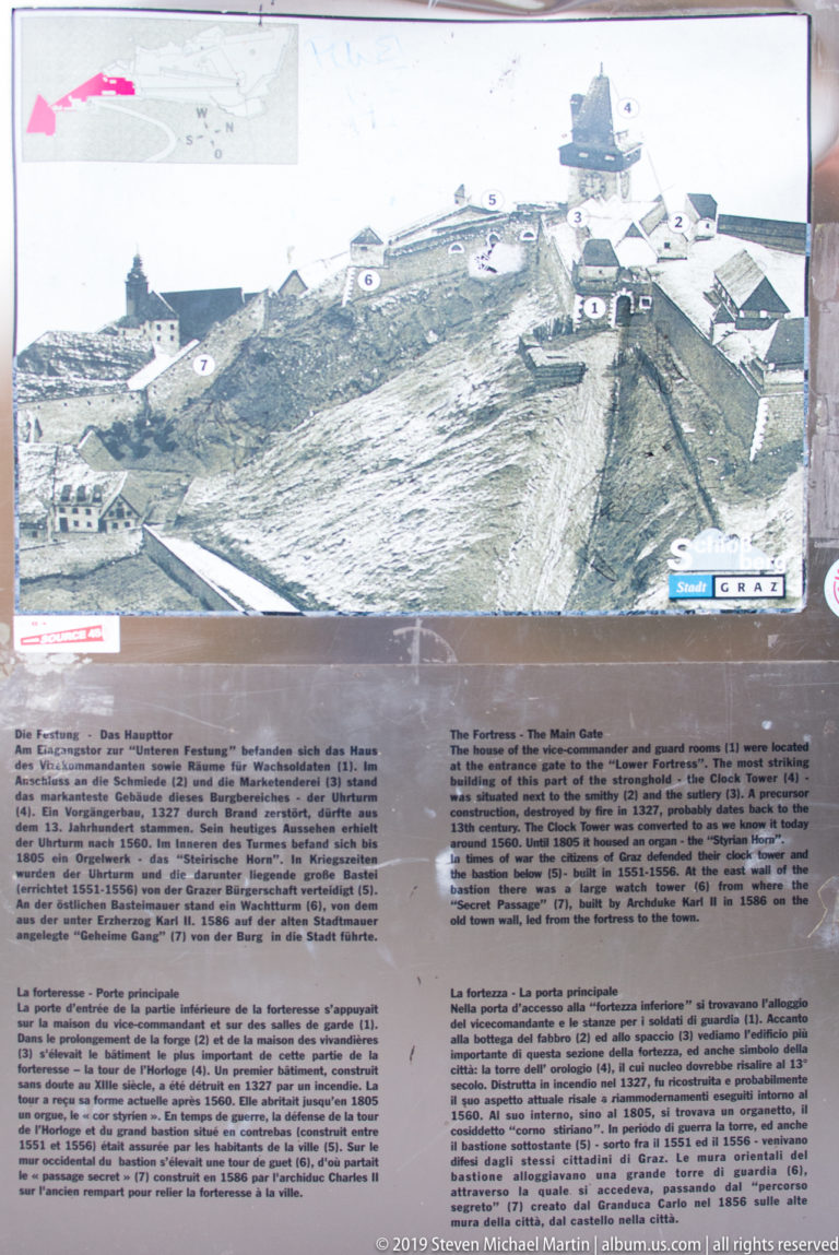 Interpretive panel with historic aerial view of Schlossberg and bilingual explanatory text.