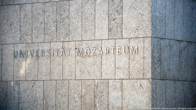 UNIVERSITÄT MOZARTEUM lettering mounted on large rectangular stone façade panels.