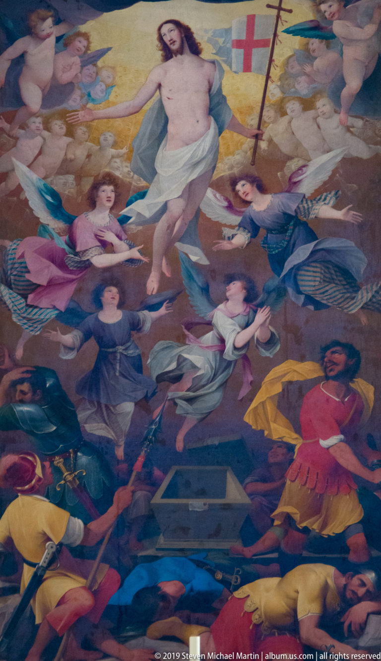 Painted Resurrection scene with Christ holding a cross-banner above angels, an open tomb, and soldiers.