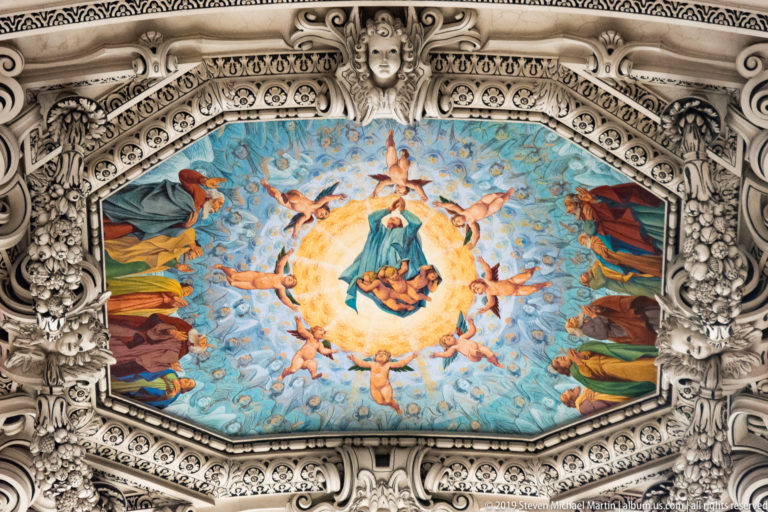 Oval ceiling fresco with a central robed figure and angels, surrounded by elaborate white stucco ornament.