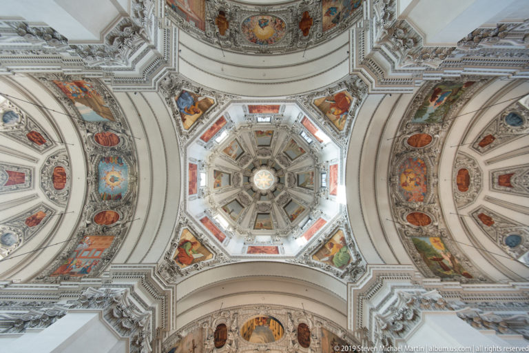 Centered upward view of Salzburg Cathedral’s octagonal dome with four surrounding painted and stuccoed vaults.