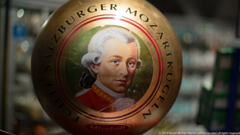 Round gold Mirabell Mozartkugel package with a portrait of Mozart and the words Echte Salzburger Mozartkugeln.