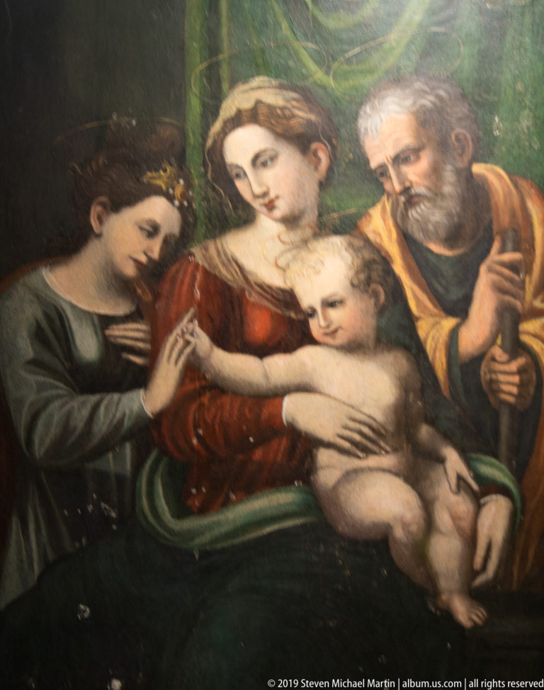 Religious painting of Mary with the Christ Child, an older bearded man, and a richly dressed female figure.