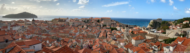 Panorama of Dubrovnik Old Town red roofs, pale stone buildings and Adriatic sea.