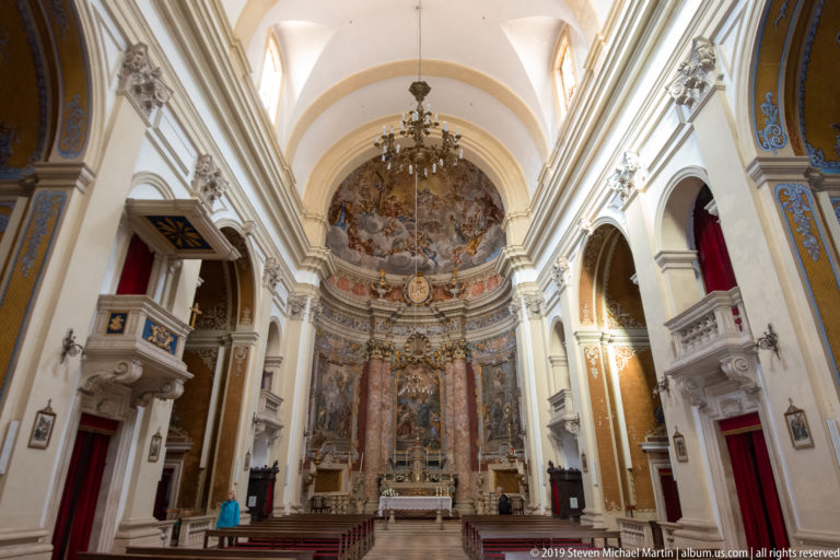 Nave and painted sanctuary of Dubrovnik’s Jesuit Church of St Ignatius, with side chapels, pulpit, chandelier, and Baroque frescoes.