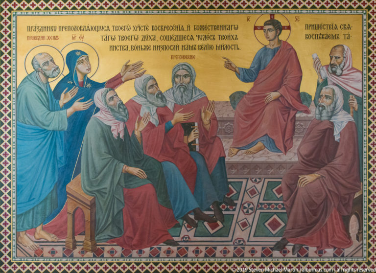 Gold-ground Orthodox mural of Christ seated among elders and disciples beneath a Cyrillic inscription.