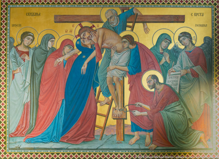 Orthodox-style mural of Christ being lowered from the cross, surrounded by haloed mourners and Cyrillic inscriptions.