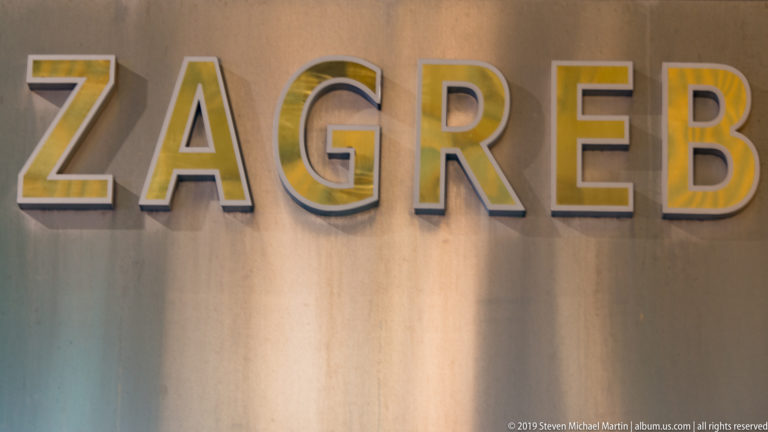 Large raised letters spelling ZAGREB mounted on a softly lit wall in a tight nighttime close-up.