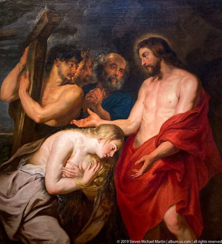 Long-haired woman kneeling at Christ’s feet in a crowded religious painting displayed in La Venaria Reale’s Annunciazione e Natività exhibition.