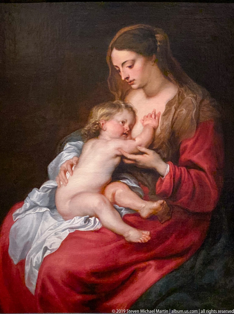 Nursing Madonna with the Virgin Mary in red and blue cradling the Christ Child, displayed in La Venaria Reale’s 2018–2019 Annunciazione e Natività exhibition.