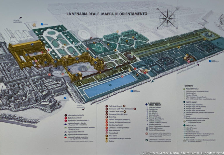 Illustrated bird’s-eye orientation map of La Venaria Reale with palace, gardens, numbered sites, legend, and compass rose.