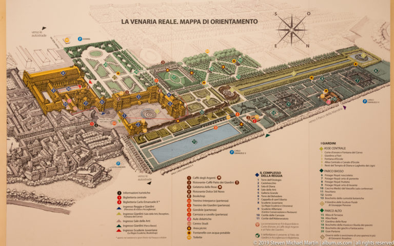 Printed orientation map showing La Venaria Reale palace buildings, formal gardens, water features, paths, and numbered visitor points.